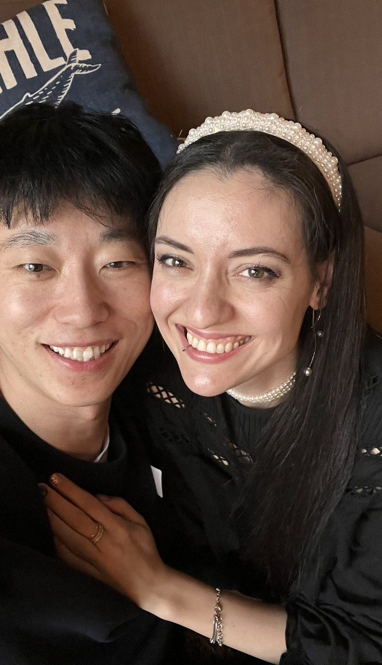 Aaron and Liuba Xu, cheek to cheek, smiling at the camera